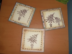 Three Christmas cards waiting for the glitter to dry.